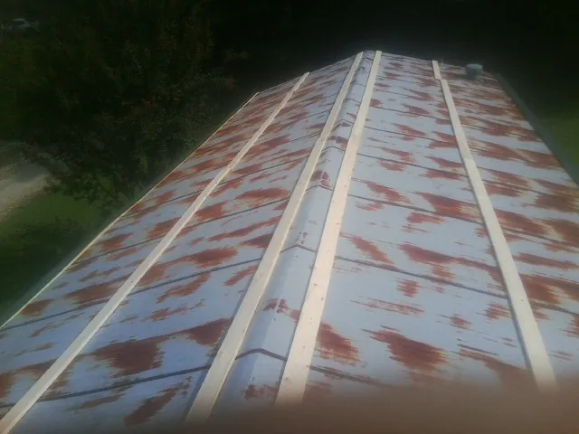 Rusted metal roof panels with new wood purlins before replacement — Storm Damage Roof Repair in Achille by Roofing Brothers