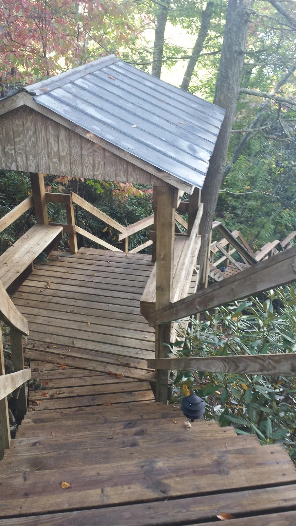 Metal roofed shelter over wooden steps on a wooded walkway — Skylight Repair & Installation work by our crew in Achille