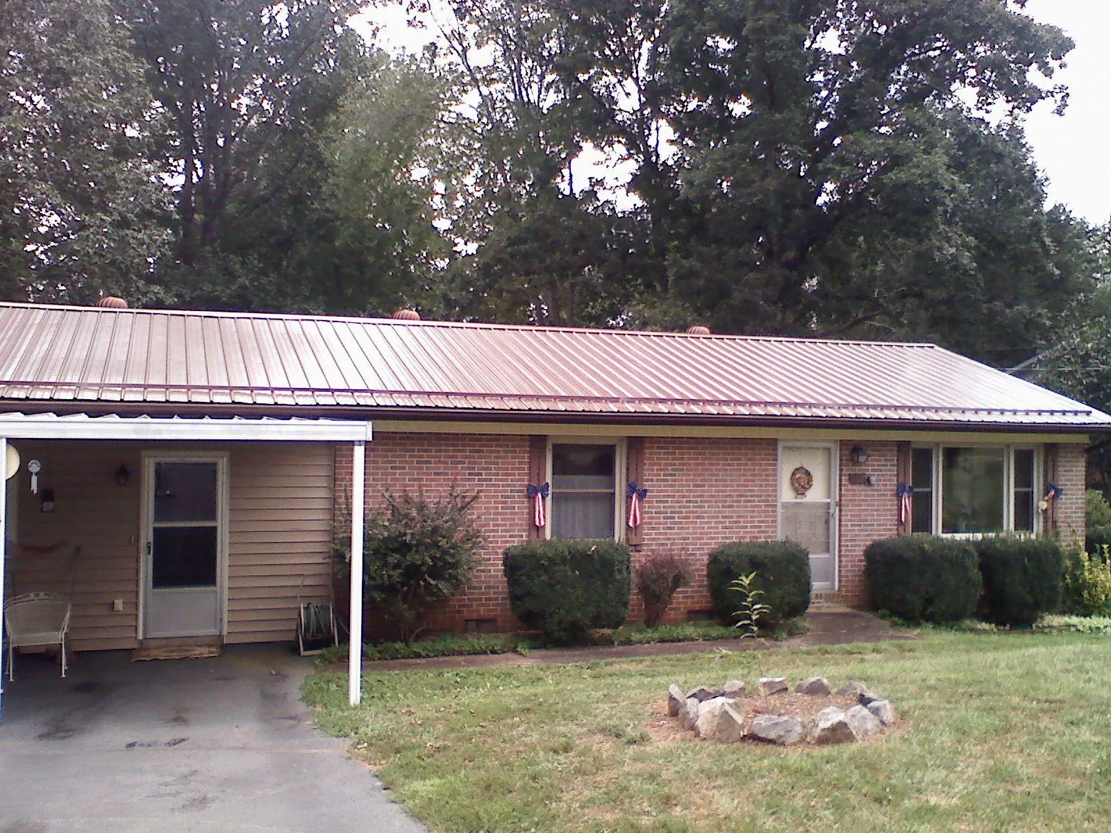 Bronze metal roof and carport on a brick ranch home — Roof Repair work by our crew in Achille